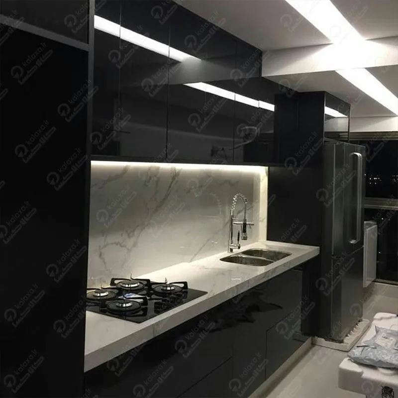 دکوراسیون آشپزخانه مدرن مشکی، ترکیبی از تضاد و هماهنگی است؛ مشکی نماد قدرت و عمق، سفید نمایانگر پاکی و روشنایی است و سنگ مرمر سفید رگه‌دار با بافت طبیعی، این تضاد را نرم و فضای لوکس و مدرن می‌سازد.