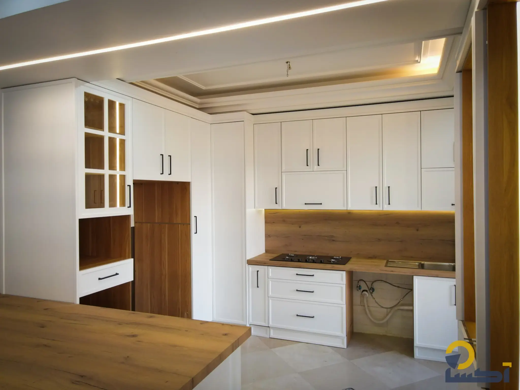 نمای آشپزخانه آرین؛ کابینتهای قابدار روشن در کنار سطوح طرح چوب